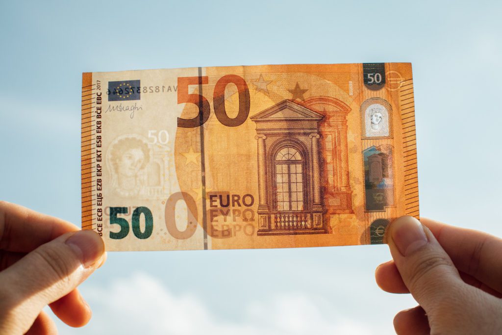 Iemand controleert de echtheid van een vijftig euro-briefje tegen het zonlicht